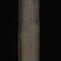 Spine of brown cloth book. Printed text. Pink cloth tape page marker.