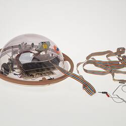 Profile of clear dome containing computer components. Cable attached.