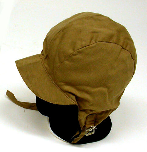 Khaki hat with ear covers and chin strap.