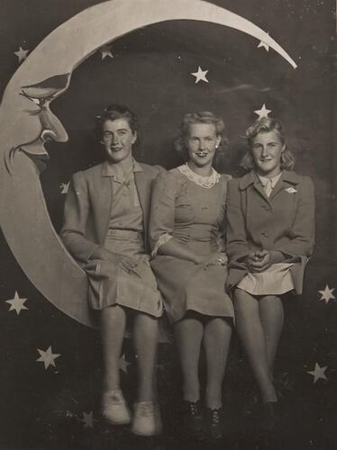 Digital Photograph - Three Girls Sitting on 'Moon' Scenic Backdrop, Luna Park, St Kilda, circa 1943