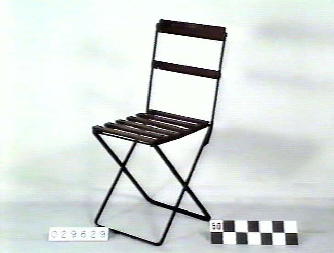 Folding metal chair with wooden slatted seat and back rest.