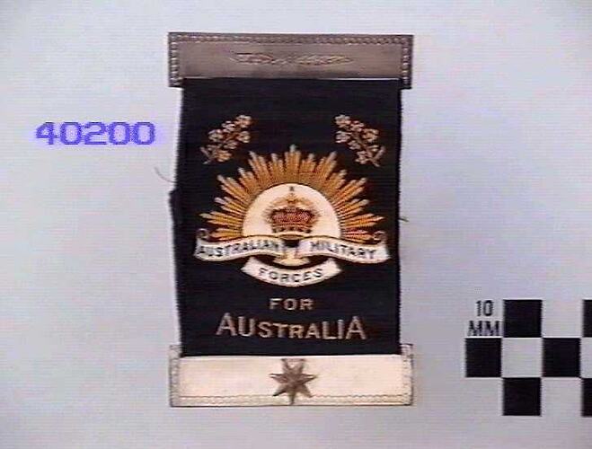 Black ribbon with embroidered rising sun badge.