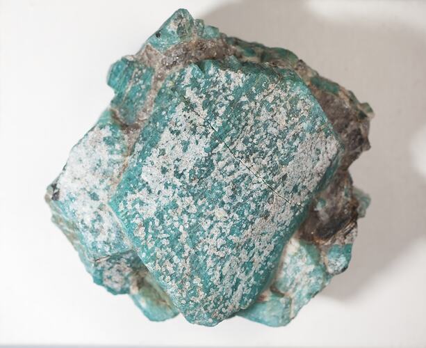 Green-blue mineral specimen with pitted surface.
