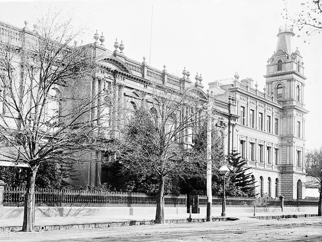 Facade of building with turrent at right.