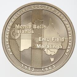 Round gold medal with outline of Australia and raised text.