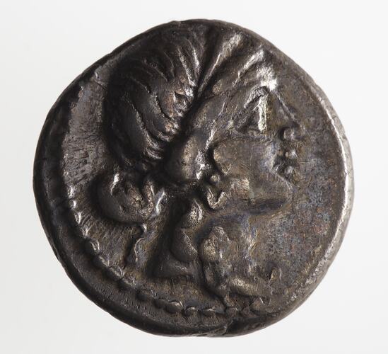 Round coin, aged, female profile, facing right, wearing headdress.
