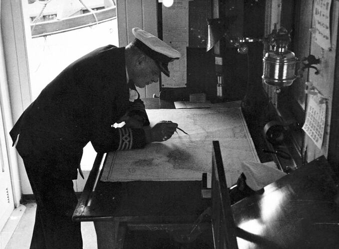[The navigator studying a chart, about 1930s.]