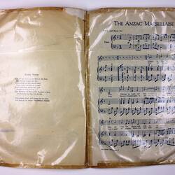 Page with printed text on right page and sheet music on left page.