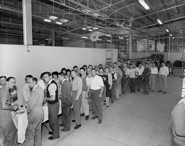 Workers in a factory queuing for lunch.