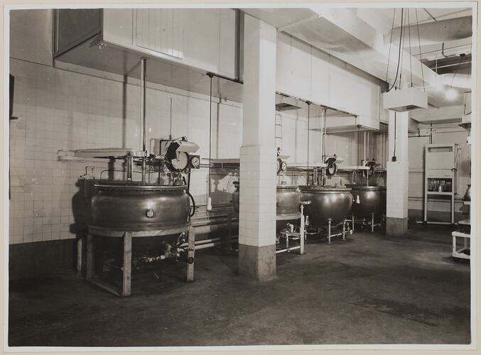 Industrial interior dominated by four round vats.