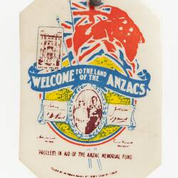 White eight-sided badge with crudely colour-printed red Australian ensign, blue scroll, royal couple and text.