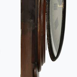 Profile of wooden wall clock with cedar drop dial case. Partially open glass.