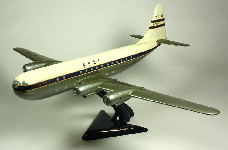 White and silver model aeroplane on black stand.