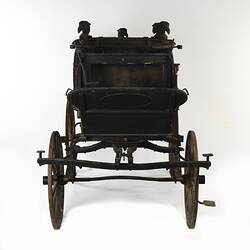 Black wooden hearse with metal base. Front view with seat.