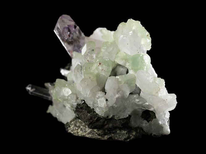 Tall purple crystal with smaller blocky green crystals.