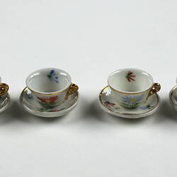 Four tea cups and saucers in a row.