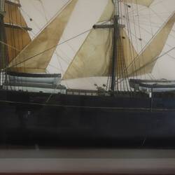 Detail of sailing ship model in glass case, facing left.