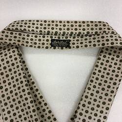 Cravat. Green and gold star pattern on cream background. Black tag detail.