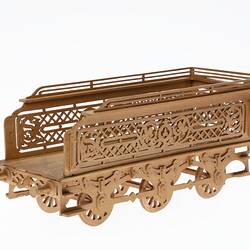 Wooden tender model made of fretwork. Has three pairs of moving wheels.