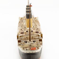 Cardboard model of passenger steamship. View of back stern section with central row of four funnels.