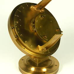 Three quarter view of gold metal chronometer.