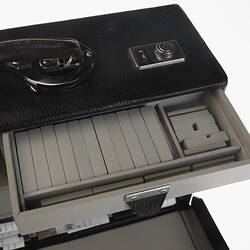 Detail of black leather briefcase. Open showing internal drawer that is open.