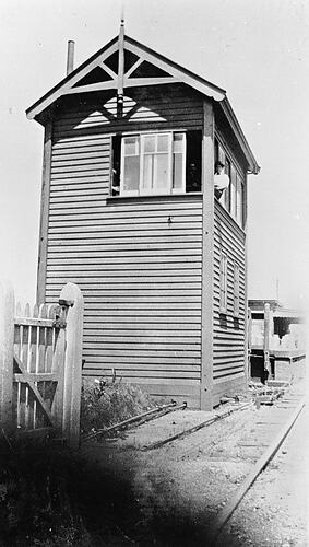 [Signalman sitting in the window of a signal box, Mentone Station, pre 1930.]