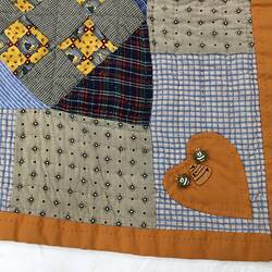 Detail of patchwork quilt. 1 heart in corner.