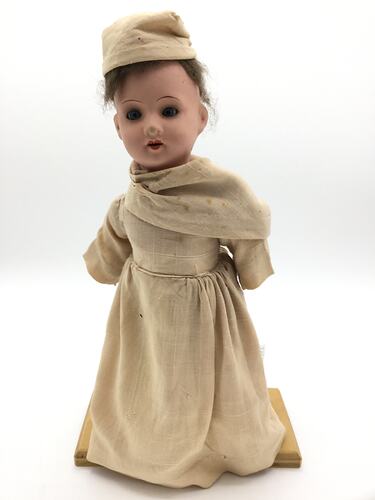 A doll dressed as a Benedictine Monk in a pale brown cassock and cap
