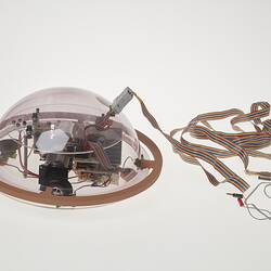 Profile of clear dome containing computer components. Cable attached.