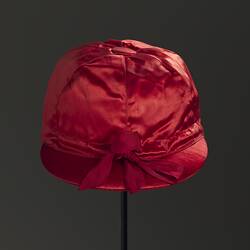 Red silk jockey cap. Black background.