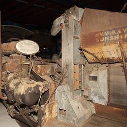 Weathered, worn self-propelled harvester with standard front, pick-up front, rice front and pea front.