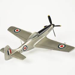 Back view of model plane painted silver. Blue, white, red roundel on sides and wings. Red, white, blue flag on tail. Front black four blade propeller.