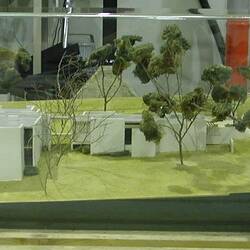 Model of buildings and trees in glass case
