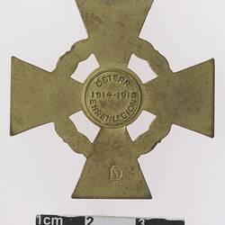 Cross shaped medal with text in centre.