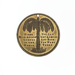 Round medal with tree fern and text.