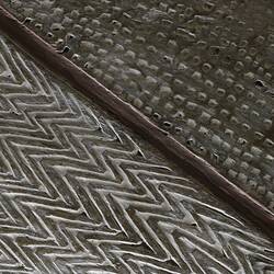 Wooden shield with incised decorations.