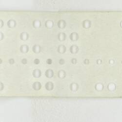 Paper tape with text and punched holes.