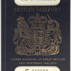 Blue passport cover with gold printed coat of arms in centre. White strip at top and bottom.