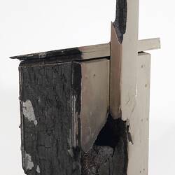 Wooden box with flap lid, charred black on one side.