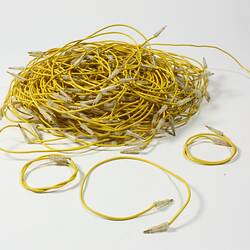Pile of yellow electrical wires with small metal pins at the ends.