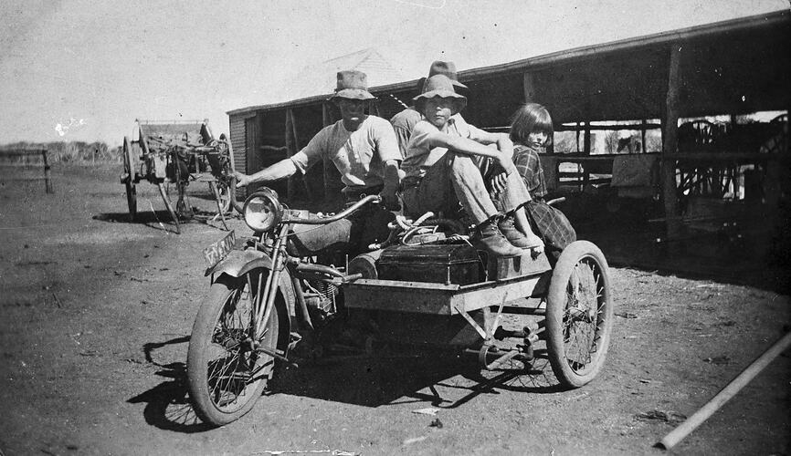 Man on motorbike with two men and a young girl on the sidecar.