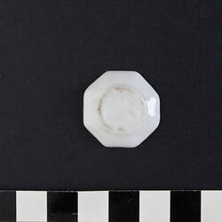 Miniature white octagonal china plate.