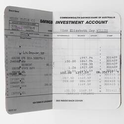 Open bank book with printed entries of monetary transactions.