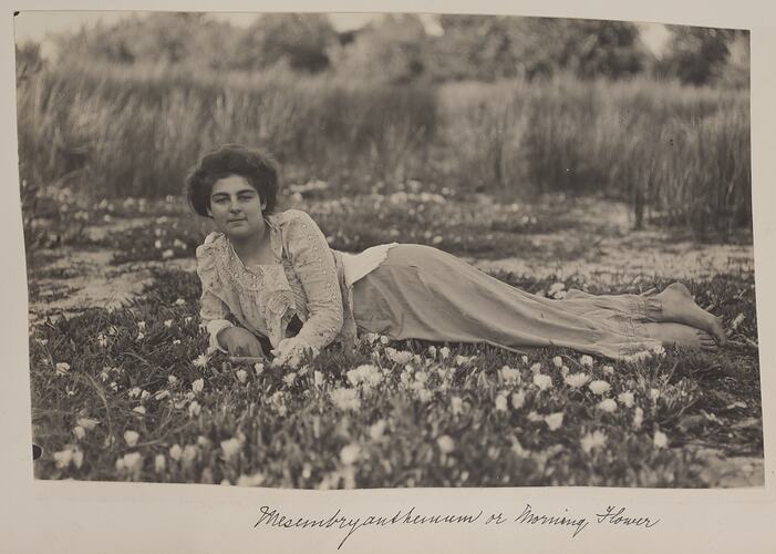 A woman lying on a bed of flowers.