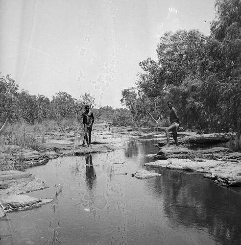 Unidentified men standing near a river, Milingimbi, Northern Territory,  late 1920s-30s