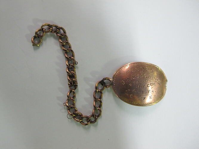 Gold identity tag on short chain.
