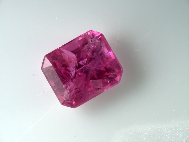 Deep pink faceted gemstone.