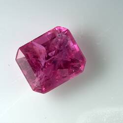 Deep pink faceted gemstone.