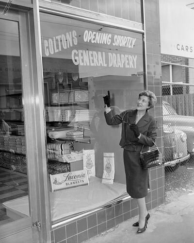 Woman Standing in Front of Coltons General Drapery Store, Toorak, Victoria, 07 Mar 1960